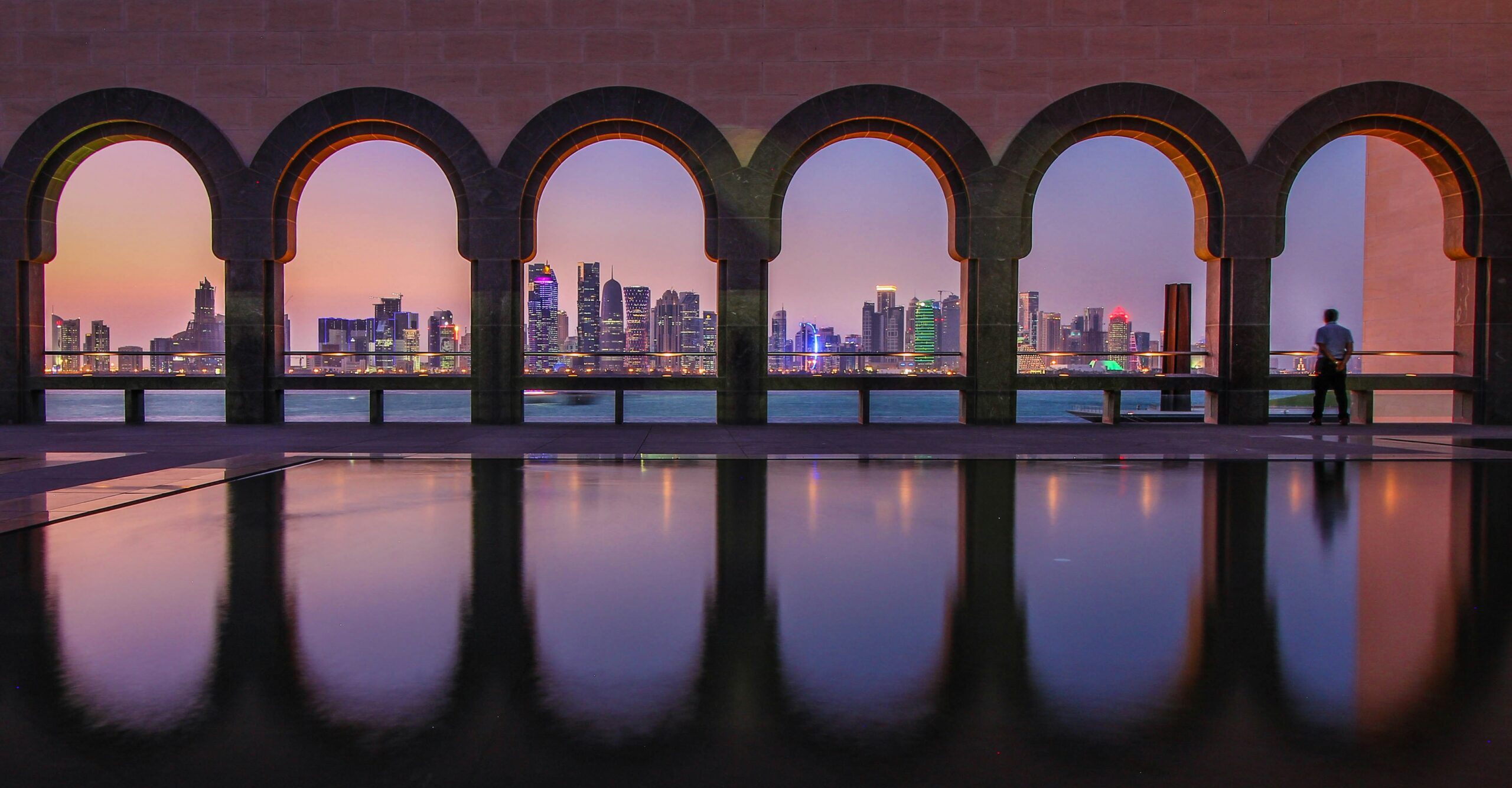 Doha Skyline bei Sonnenuntergang durch Arkaden des Museums von Katar
